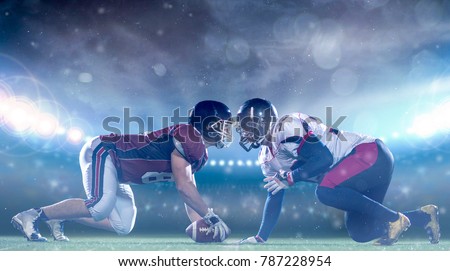 american football players are ready to start a match on modern field at night