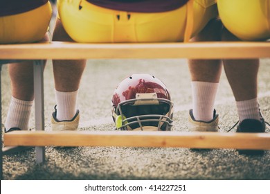 American Football Players Sitting On A Bench.