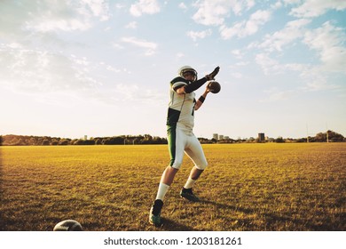 American Football Quarterback About To Throw A Football During Team Practice Drills On A Sports Field In The Afternoon