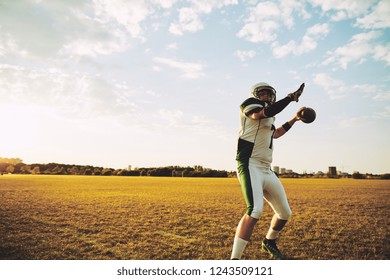 American Football Quarterback Making A Long Throw During Team Practice On A Sports Field In The Afternoon