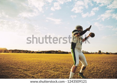 American football quarterback making a long throw during team practice on a sports field in the afternoon