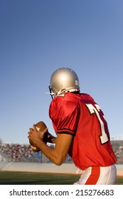 American Football Quarterback, In Red Strip, Looking To Throw Ball During Competitive Game, Rear View