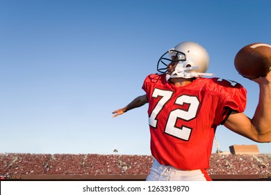 American football quarterback in stadium throwing ball