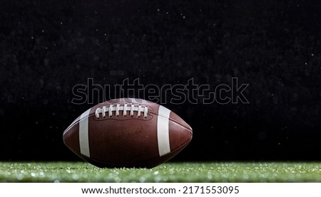 American Football resting on the field of a Football stadium during a game. Copy space and good football abstract photo