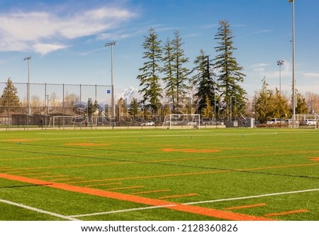 American football and soccer field and grass in sunny spring day. Street view, selective focus