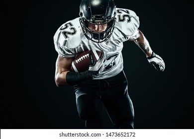 American Football Sportsman Player In Helmet Isolated Run In Action On Black Background. Sport And Motivation Wallpaper.