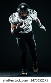 American football sportsman player in helmet isolated run in action on black background. Sport and motivation wallpaper.