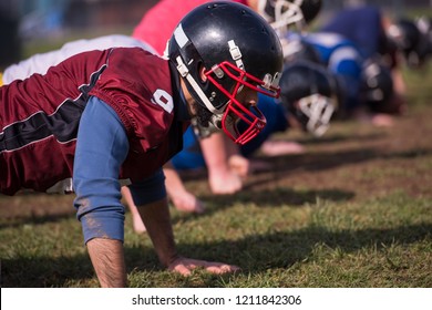 american football team doing push ups during training at the field - Powered by Shutterstock