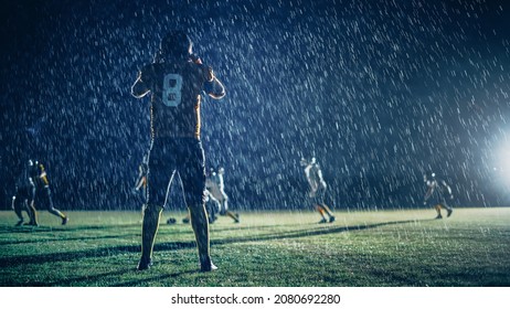 American Football Teams Compete: Substitution Athlete Warrior Stands On Field Ready To Win The Game. Players Run, Attack To Score Touchdown. Rainy Night With Dramatic Fog