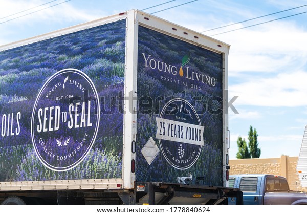 American Fork, USA - July 29, 2019: Sign for\
Young Living Essential Oils company delivery truck near warehouse\
on highway road in Utah cars in\
traffic