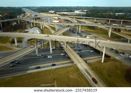 American freeway intersection with fast driving cars and trucks. View from above of USA transportation infrastructure
