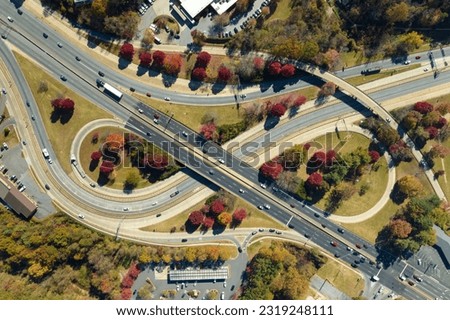 American freeway intersection with fast driving cars and trucks. View from above of USA transportation infrastructure