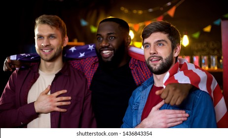 American Friends Wrapped In National Flag Watching Election Results On Tv