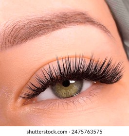 The American girl has green eyes and Classic eyelash extensions that look very natural. Eyelash extension