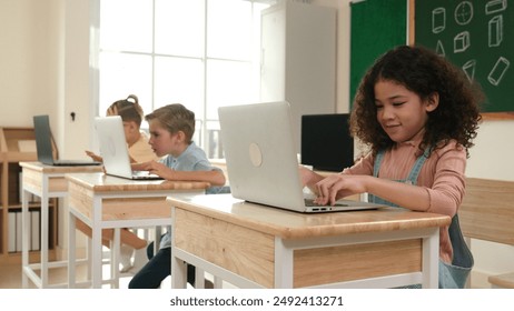 American girl learning about coding engineering prompt while diverse students sitting at STEM technology class. Multicultural children working on laptop to generated AI by using software. Pedagogy.