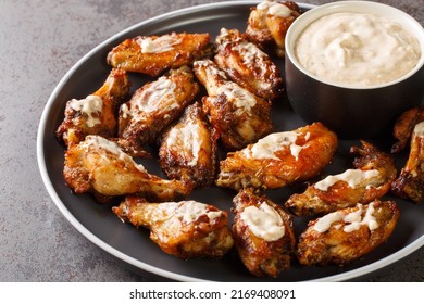 American Grilled Chicken Wings With Alabama White BBQ Sauce Close-up In A Plate On The Table. Horizontal
