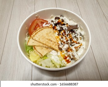 American Halal Platter Of Chicken And Gyro Meat With Rice. Popular Delivery Food From Halal Fast Casual Restaurant Franchise. Served With Lettuce, Tomato, Pita, And White And Red Hot Sauce.