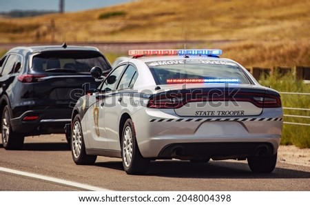 American Highway State Trooper Pulling Over Vehicle For Speeding Reason.