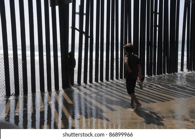 American Kid Meets Mexican Kid On The Other Side Of The Fence. USA Mexico Border, San Diego Tijuana.