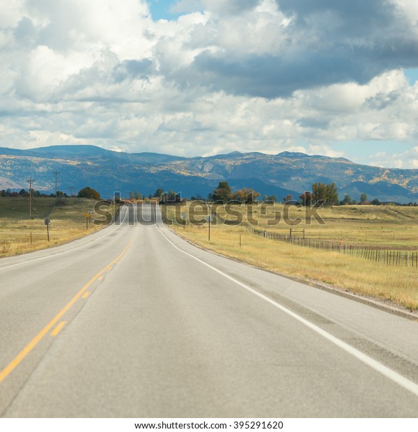 American landscape across long
endless asphalt mountain road in beautiful sunny, Colorado,
USA