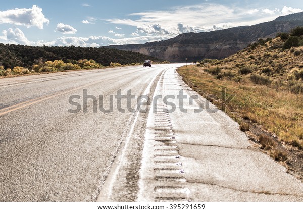 American landscape across long\
endless asphalt mountain road in beautiful sunny, Colorado,\
USA