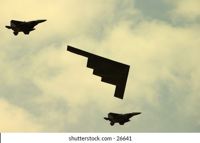 American large stealth bomber escorted by two small fighter planes