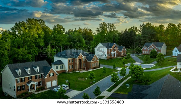 American luxury real estate single family\
houses with brick facade and two car garages in a new construction\
Maryland street neighborhood USA aerial\
view