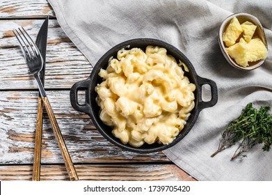 American mac and cheese, macaroni pasta in cheesy sauce. White wooden background. Top view