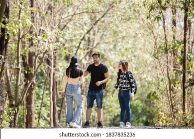 American Man And Asian Women Adventure Travel Backpack Hiking, Happy Couple Walking In Forest.