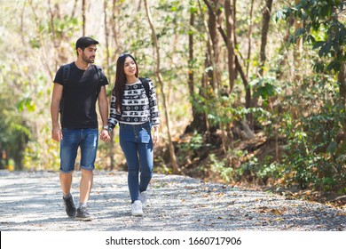 American Man And Asian Women Couple Adventure Travel Backpack Hiking, Happy Couple Walking In Forest.