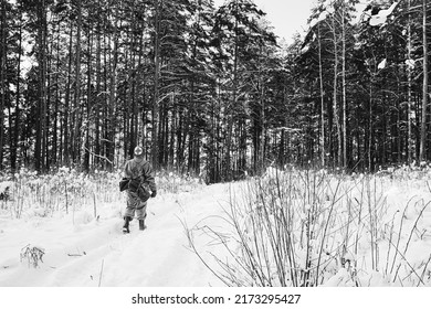 American Medic Soldier Of USA Infantry Of World War II Marching Along Forest Road In winter Day. Photo In Black And White Colors.