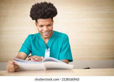 American Medical Student Is Reading A Book To Prepare For An Exam In A Hospital.