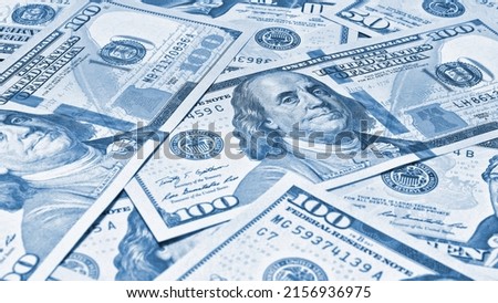 American paper money. 100 dollar and other US notes. Light blue tinted wallpaper or background. Savings economy and the USA dollar. National debt and Treasury
