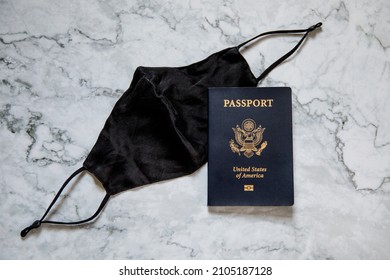 American Passport And Black Face Mask On White Marble Background, Covid Travel, Traveling With Covid, Pandemic Travel