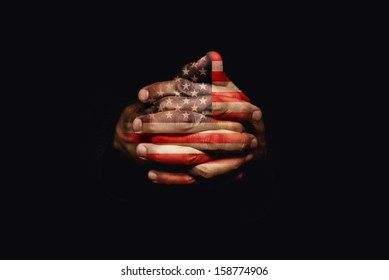 American patriot praying with crossed hands with USA flag painted on fingers for 4th of July