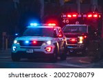 American Police Car and Emergency truck with Blue and red lights. US Paramedic Fire Rescue resuscitation help. Investigation Crime, murder, theft, police arrest. Photo has a dramatic toning.