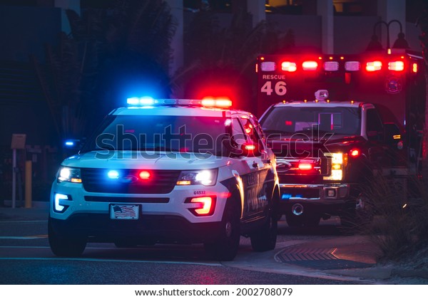 American Police Car and Emergency truck with Blue\
and red lights. US Paramedic Fire Rescue resuscitation help.\
Investigation Crime, murder, theft, police arrest. Photo has a\
dramatic toning.