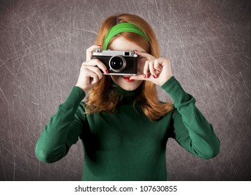 American redhead girl with camera. Photo in 60s style.