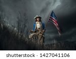 American revolution war soldier with flag of colonies and saber over dramatic landscape. 4 july independence day of USA concept photo composition: soldier and flag.