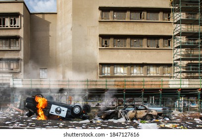 American riots and protests cause vandalism, looting and destruction, riot aftermath concept, upturned police car smashed on fire, broken windows of abandoned building, total anarchy and lawlessness - Shutterstock ID 1847127616