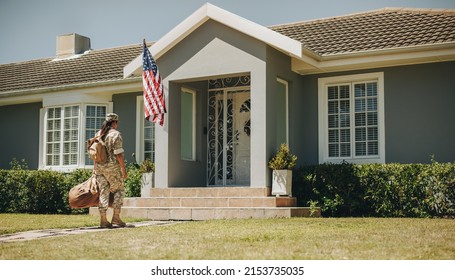 American Servicewoman Walking Towards Her House With Her Luggage. Courageous Female Soldier Coming Back Home After Serving Her Country In The Military.