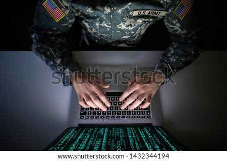 American soldier in military uniform preventing cyber attack in military intelligence center. An US officer intercepting messages to stop terrorism. Modern warfare system surveillance concept.