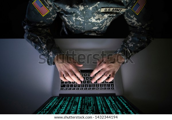 American soldier in military uniform preventing\
cyber attack in military intelligence center. An US officer\
intercepting messages to stop terrorism. Modern warfare system\
surveillance concept.