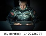 American soldier in military uniform using high tech computer in headquarters intelligence center. Focus on US ARMY tag and USA flag patch on uniform.