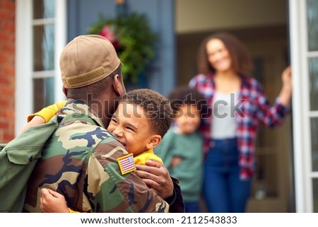 American Soldier In Uniform Returning Home To Family On Hugging Children Outside House