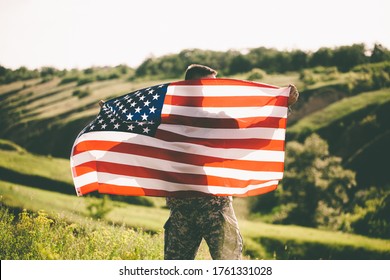 American soldier with usa flag on his back looks into the distance.
United States Army. Veterans Day