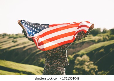 American soldier with usa flag on his back looks into the distance.
United States Army. Veterans Day