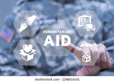 American soldier using virtual touchscreen presses of inscription: HUMANITARIAN AID. Concept of humanitarian aid. Help refugees, volunteering and rescue during the war. Humanitarian aid day.