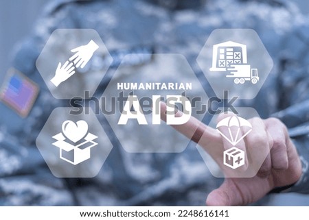 American soldier using virtual touchscreen presses of inscription: HUMANITARIAN AID. Concept of humanitarian aid. Help refugees, volunteering and rescue during the war. Humanitarian aid day.