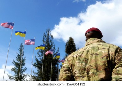 American Soldiers And Flags Of The Ukraine And USA At Background. US Military Help To Ukraine.